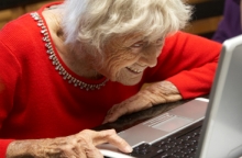 Elderly lady looking over a laptop