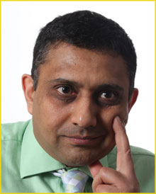 Sanjay Morzaria wearing a green shirt with a concentrated look.